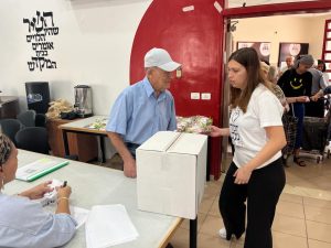 Sharon collaboratrice de Hasdei Naomi aidant un bénéficiaire 