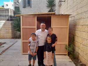Photo d'une famille qui a reçu une aide pour la construction de sa souccah
