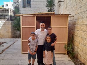 Une famille qui pose avec sa souccah 