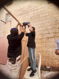 Bénévole qui aide activement pour construire la souccah avec l'aide d'un membre de la famille 